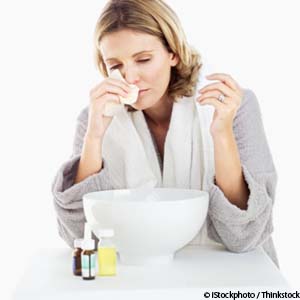 close-up of a young woman using a tissue in front of a bowl