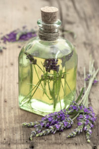 bottle of lavender oil with fresh flowers on wooden background. apothecary herbs. selective focus