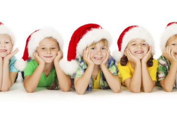 Group of happy Christmas kids in Santa hat lying down. White background.