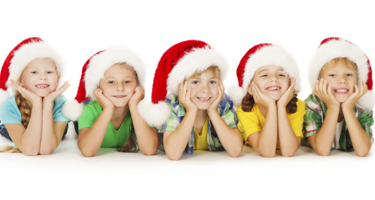 Group of happy Christmas kids in Santa hat lying down. White background.