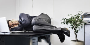 Businessman asleep on his office desk