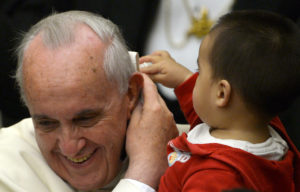 A child plays with Pope Francis' skull cap during an audience with beneficiaries and volunteers of the Santa Marta pediatric dispensary in Paul VI Audience Hall in the Vatican on December 14, 2013. AFP PHOTO / ALBERTO PIZZOLI (Photo credit should read ALBERTO PIZZOLI/AFP/Getty Images)