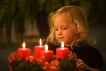 Kind mit Adventkranz zu Weihnachten