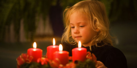 Kind mit Adventkranz zu Weihnachten