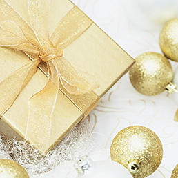 Gold Christmas gift and Christmas ornaments --- Image by © Ada Summer/Corbis